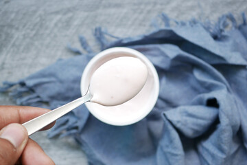 fresh yogurt on silver spoon on table 