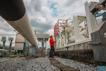 Male worker inspection at steel long pipes and pipe elbow in station oil factory during refinery...