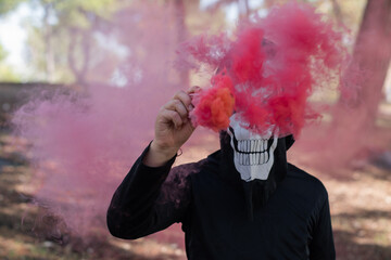 Kid dressed up for Halloween with colored smoke