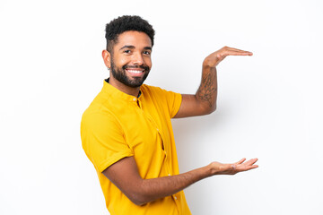 Young Brazilian man isolated on white background holding copyspace to insert an ad