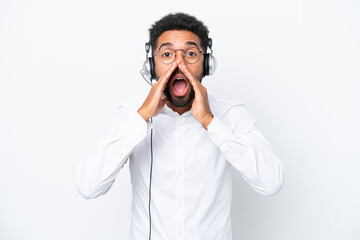 Telemarketer Brazilian man working with a headset isolated on white background shouting and announcing something