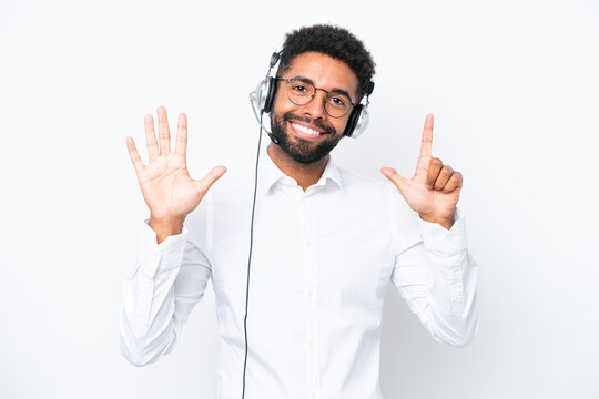 Telemarketer Brazilian man working with a headset isolated on white background counting seven with fingers