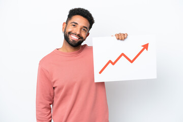 Young Brazilian man isolated on white background holding a sign with a growing statistics arrow symbol with happy expression