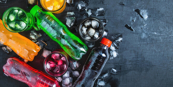 Top view  lot of bottles Soft drinks in colorful and flavorful  on the table, Glasses with sweet drinks with ice cubes