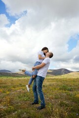 Fototapeta na wymiar Loving young couple in white t-shirts running across the field. Happy moments in lovers lives.
