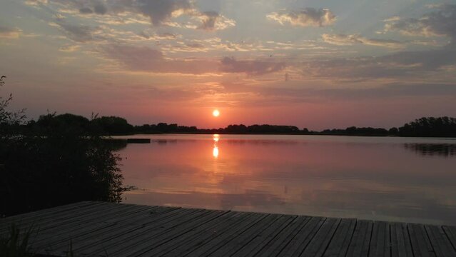 Sunrise above lake in bird sanctuary near Cambridge England on the moorning of the hottest day ever recorded in England