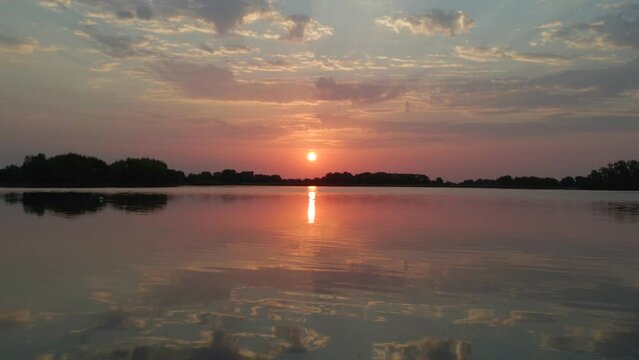 Sunrise above lake in bird sanctuary near Cambridge England on the moorning of the hottest day ever recorded in England