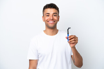 Young Brazilian man shaving his beard isolated on white background smiling a lot