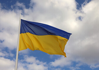 Blue and yellow flag of Ukraine with blue sky and clouds