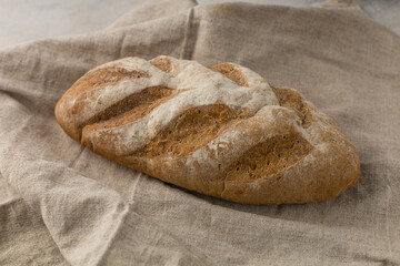 Gluten free fresh bread in kitchen towel on light background