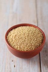Dry couscous in a small ceramic bowl	