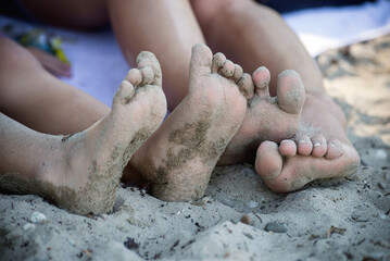 Closeup of feet covered by sand on the beach