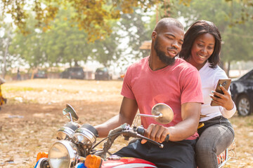 african lady on a bike and the rider view content on phone
