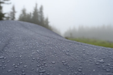 Raindrops on a blue tent close-up. Foggy morning in the Carpathians.