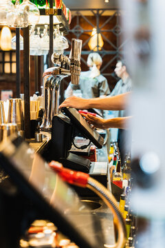 barman behind till at pub