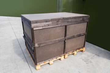Big wooden box on two pallets. Huge case for industrial equipment. Box for storage of industrial equipment. Two pallets with wooden box on ground. Wood casing for industrial equipment