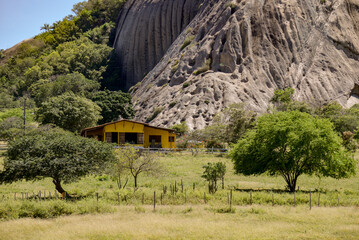 yellow house at the foot of the mountain, rocks in the mountains, rocks with mosses in the...