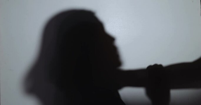 Victim, abuse and domestic violence, Silhouetted of a woman being abused and strangled by strong man
