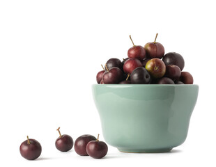 cup of governor's plum fruits, flacourtia indica, also known as ramontchi, madagascar plum or indian plum, reddish black fleshy fruits isolated on white background