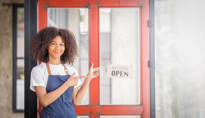 Startup successful african american small business owner sme Smiling owner in blue apron standing at coffee shop entrance leaning on door with open signboard,SME entrepreneur seller business.