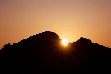 landscape with sun rising behind rocks