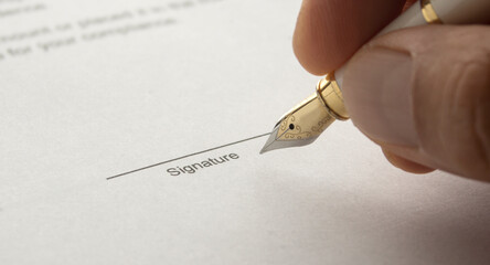 hand holding a fountain pen to sign a document. signature. Sign a document. 