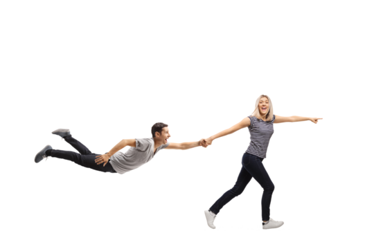 Full length profile shot of a happy young woman pulling a young man by the hand and pointing