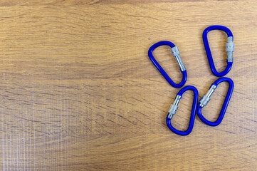 Four of blue HMS carabiner with automatic twist lock , climbing equipment on a wooden table, Copy...