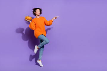 Full length body size view of stunned trendy girl jump with pumpkin showing copy space isolated on shine violet purple color background