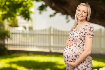Fototapeta premium Pregnant woman walking in park during summer. Pregnancy care