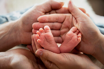 Close up view of baby feet. Mother touching her small child's toes while he is asleep. Baby toe. Newborn close up photography. Tiny beautiful baby's feet. Macro shot of infants toes. 