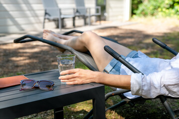 Woman relaxing in a sun lounger in the suburb. Summer in the suburb.