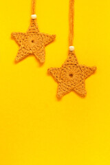 Fototapeta na wymiar Two crochet yellow star on a yellow background. Handmade Christmas decoration. Top view. Copy space.