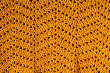 Yellow crochet texture with chevron stitch. Crochet fabric with zigzag pattern.