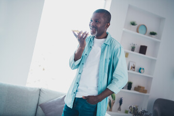 Fototapeta premium Photo of positive aged man recording voice message use speaker phone application in modern house apartment