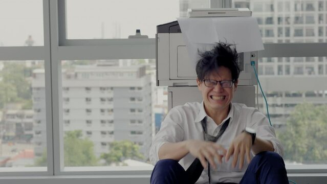 Overload office worker. Alone stressed and sad  asian office worker is sitting beside error copy machine at the office.