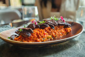 Primer plano churrasco angus sobre arroz amarillo con verduras, toques de plátano maduro y aguacate. Concepto de comida de alto nivel