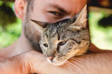 Close-up portrait of a man hugging his cat.