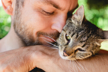 Man hugging his cat, affection of owners to their pets.