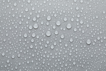 Water drops on grey background, top view