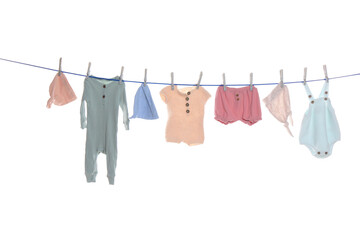 Colorful baby clothes drying on laundry line against white background