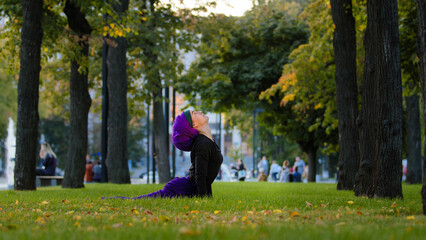 Muslim islamic woman practice yoga sun salutation in park on grass morning routine up facing dog pose asana for body care healthy spine stretching flexibility. Girl in hijab productive practicing