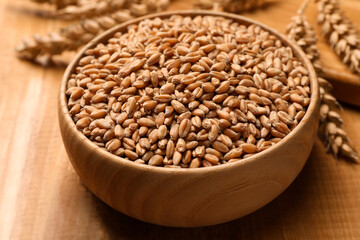 Wheat grains with spikelets on wooden table, closeup