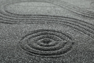 Fototapeta na wymiar Pattern on decorative black sand, closeup. Zen and harmony