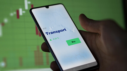 An investor's analyzing the  on screen. A phone shows the ETF's prices transport