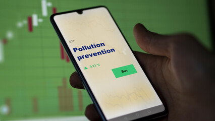 An investor's analyzing the pollution prevention etf fund on screen. A phone shows the green, climate, ecologic sustainable ETF's prices stocks to invest