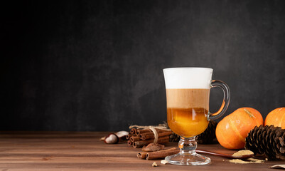 Pumpkin spice latte in a glass mug with cinnamon and ginger