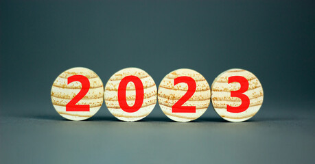 2023 happy new year symbol. Wooden circles symbolize the change from 2022 to the new year 2023. Beautiful black table black background. Copy space. Business and 2023 happy new year concept.