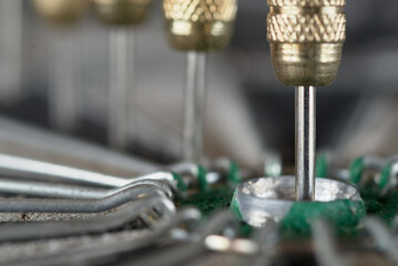 Lots of darts are stuck into the dartboard in a line across the center