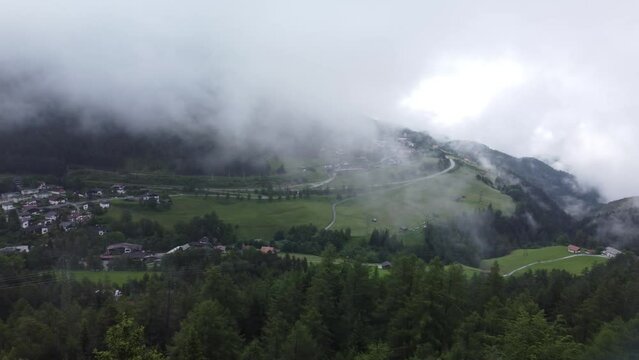 Aerial shot of the Reith bei Seefeld in Austria, with forest trees and houses on a cloudy day